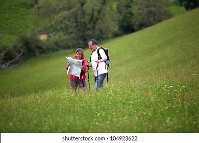 Senior hikers reading map in country field - Powered by Shutterstock