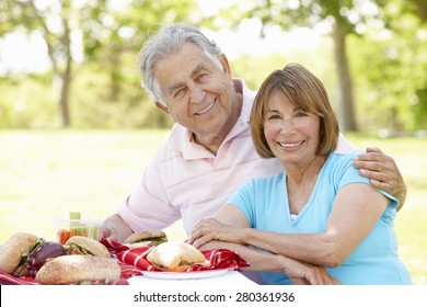 Senior Hispanic Couple Enjoying Picnic In Park