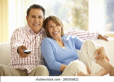 Senior Hispanic Couple Watching TV At Home