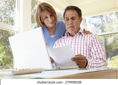 Senior Hispanic Couple Working In Home Office