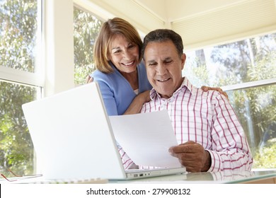 Senior Hispanic Couple Working In Home Office