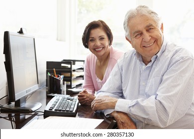 Senior Hispanic Couple Working On Computer At Home