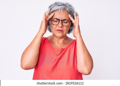 Senior Hispanic Grey- Haired Woman Wearing Casual Clothes And Glasses With Hand On Head For Pain In Head Because Stress. Suffering Migraine. 