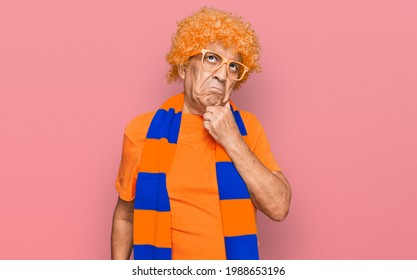 Senior Hispanic Man Football Hooligan Cheering Game Serious Face Thinking About Question With Hand On Chin, Thoughtful About Confusing Idea 