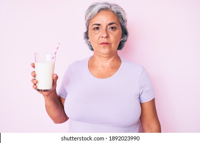 Senior Hispanic Woman Holding Glass Of Milk Thinking Attitude And Sober Expression Looking Self Confident 