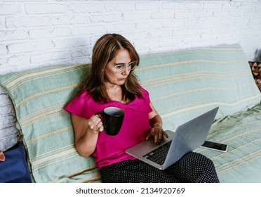 Senior Hispanic Woman Middle Age Working With Computer At Home In Sofa Or Home Office In Mexico Latin America
