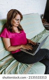 Senior Hispanic Woman Middle Age Working With Computer At Home In Sofa Or Home Office In Mexico Latin America