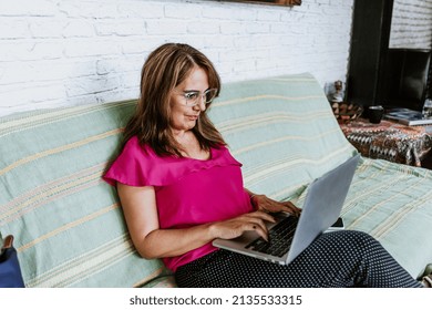 Senior Hispanic Woman Middle Age Working With Computer At Home In Sofa Or Home Office In Mexico Latin America