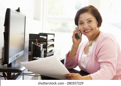 Senior Hispanic Woman Working On Computer At Home