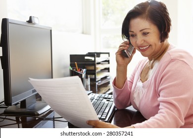 Senior Hispanic Woman Working On Computer At Home