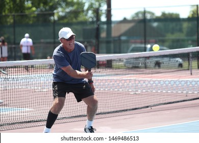 A Senior Hits A Pickleball Shot During A Tournament