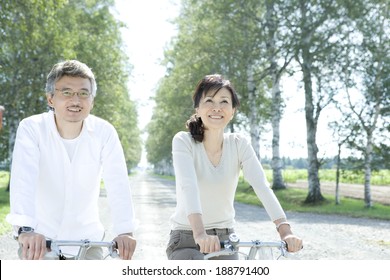 senior husband and wife riding on bicycle