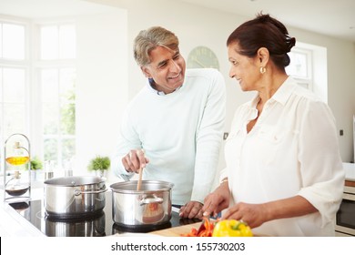 Senior Indian Couple Cooking Meal At Home