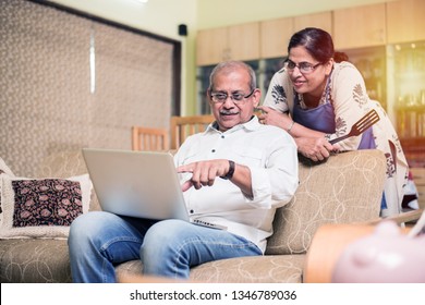 Senior Indian/asian Couple Accounting, Doing Home Finance And Checking Bills With Laptop, Calculator And Money While Sitting On Sofa/couch At Home