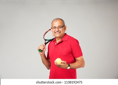 Senior indian/asian healthy sportsman playing individual sport, isolated on plain background