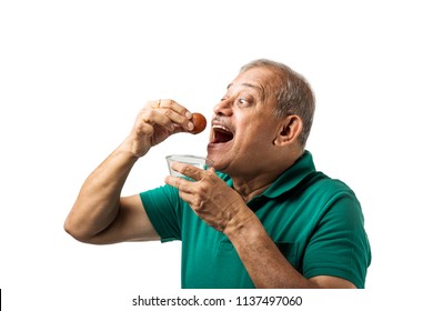 Senior Indian/asian Man Eating Sweet Gulab Jamun With Spoon