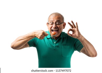 Senior Indian/asian Man Eating Sweet Gulab Jamun With Spoon