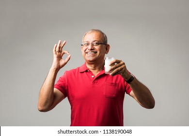 Senior Indian/asian man with a glass of milk and or fresh apple - healthy old age concept - Powered by Shutterstock