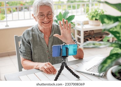 Senior influencer woman creating social media videos with smartphone camera - New digital jobs trends, technology, concept - Focus on her face - Powered by Shutterstock