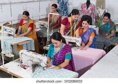 Senior inspector explaining women textile worker sewing garment on production line