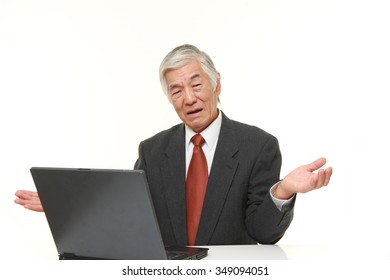 Senior Japanese Businessman Using Computer Looking Confused