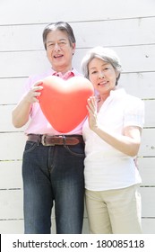 Senior Japanese Couple Outside With A Heart Balloon