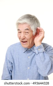 Senior Japanese Man With Hand Behind Ear Listening Closely