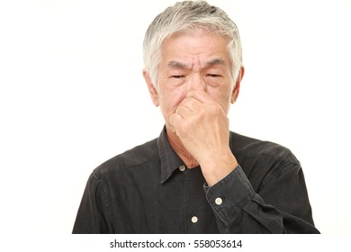 Senior Japanese Man Holding His Nose Because Of A Bad Smell