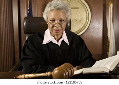 Senior Judge Sitting With Book In Courtroom