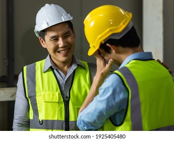 Senior and junior engineers talking together with intimated manner beside the machine in factory. Concept for good teamwork and unity of colleauges.