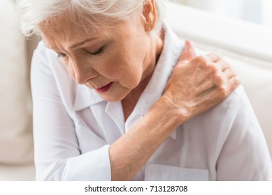 Senior lady is demonstrating suffering from ache - Shutterstock ID 713128708
