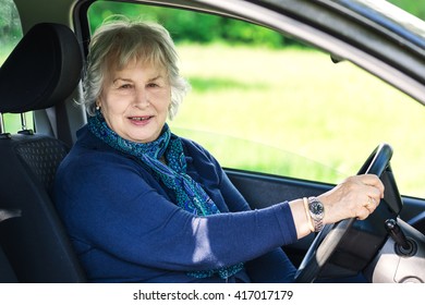 Senior Lady Driving  A  Car In Country Scene