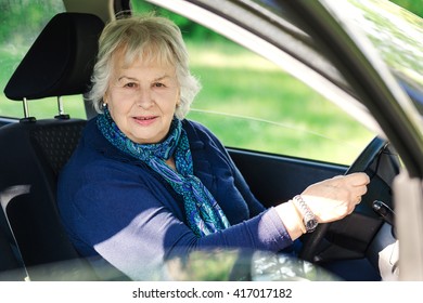 Senior Lady Driving  A  Car In Country Scene