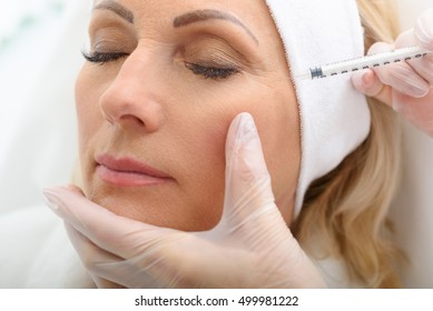Senior lady having botox injecting procedure