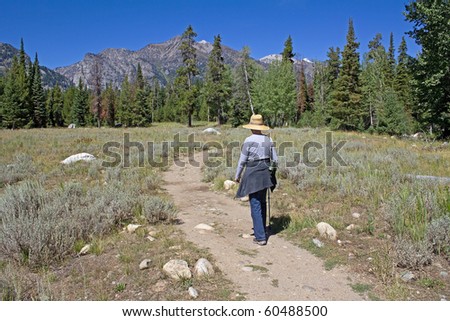 Senior lady hiking along Lake Phelps Trail in Grand Teton National Park in Wyoming Summer.