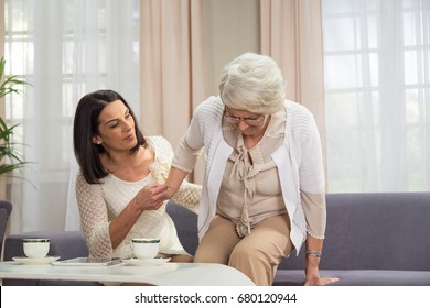 Senior lady with hip problem stand up with assistance from adult female