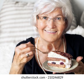 Senior Lady Looking Happy At Camera, She Likes To Eat A Piece Of Cream Cake 