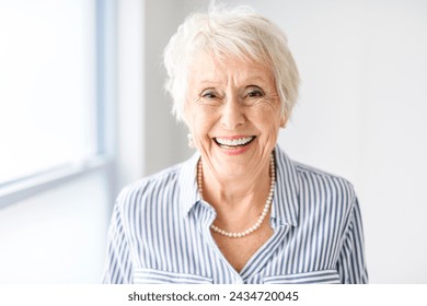 A senior lady posing at home portrait close to a window - Powered by Shutterstock