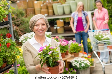 Senior Lady Shopping For Flowers At Garden Centre Smiling