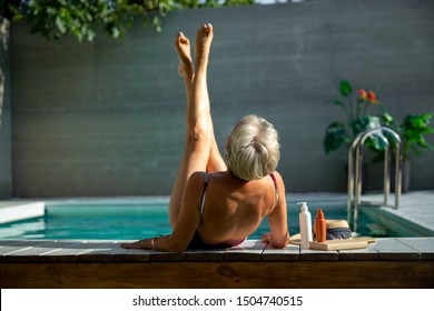 Senior Lady In Swimsuit Lifting Up Her Legs Stock Photo