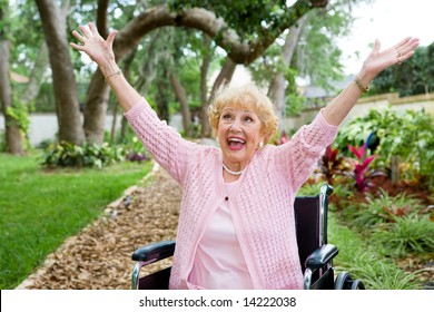 Senior lady in wheelchair is ecstatic as she celebrates freedom from pain.