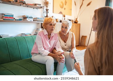 Senior lesbian couple talking to financial advisor at home - Powered by Shutterstock