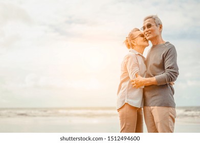 Senior Lovers Hug And Kiss Each Other In The Sunset On The Beach Plan Life Insurance With A Happy Retirement Concept.