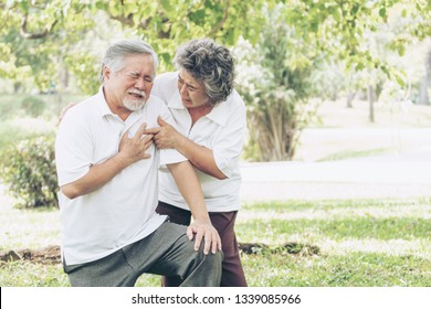 Senior Male Asian Suffering From Bad Pain In His Chest Heart Attack At Garden Park , Wife Supporting Husband - Elderly Couple Senior Heart Disease