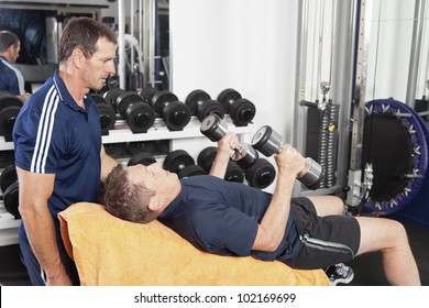 Senior Male Being Spotted By Personal Trainer