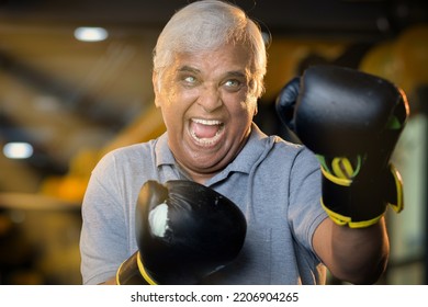 Senior Male Boxer Training With Punching Bag