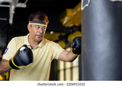 Senior Male Boxer Training With Punching Bag