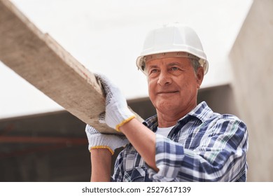 Senior male carpenter with planks on shoulder - Powered by Shutterstock