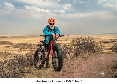 Senior Male Cyclist With A Fat Mountain Bike On A Single Track Trail In Northern Colorado Grassland, Early Spring Scenery In Soapstone Prairie Natural Area Near Fort Collins