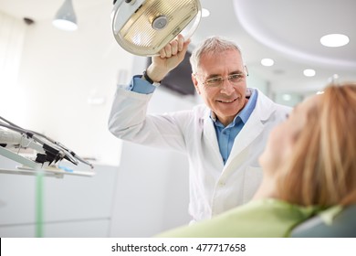 Senior Male Dentist Adjust Searchlight Before Starting Work